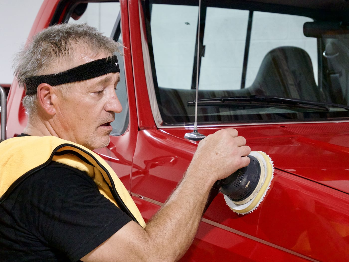 Close-up of Mike correcting the panel of a red truck